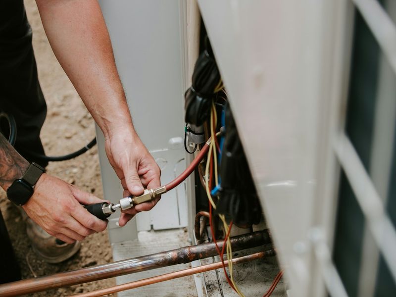 HVAC contractor loading tools into a service van outside a customer's home