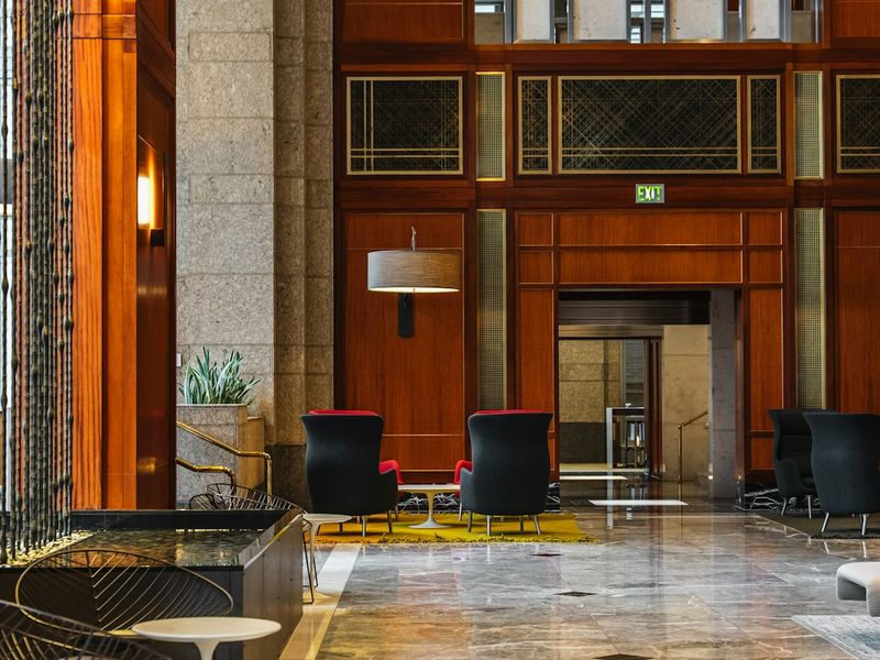 Hotel owner greeting guests at the front desk of a renovated hotel lobby